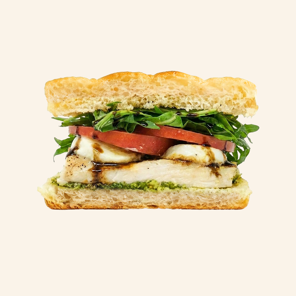CHICKEN CAPRESE - All natural chicken, Buffalo mozzarella, basil pesto, tomato, arugula, topped with a balsamic glaze on housemade organic focaccia.