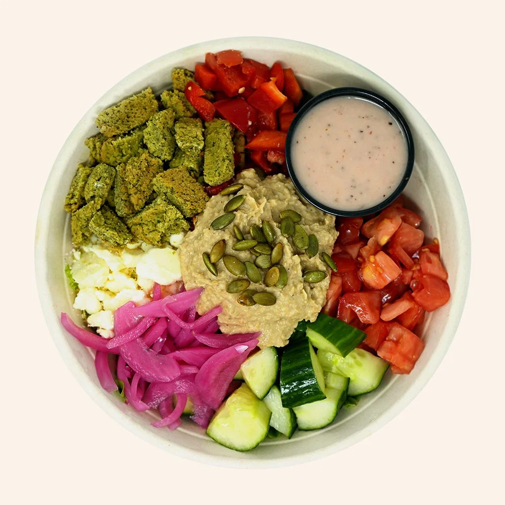 MEZZE FALAFEL - Spring mix, baked falafel, feta cheese, tomato, red bell pepper, cucumbers, pickled onions, topped with hummus and toasted pumpkin seeds with Mediterranean red wine.