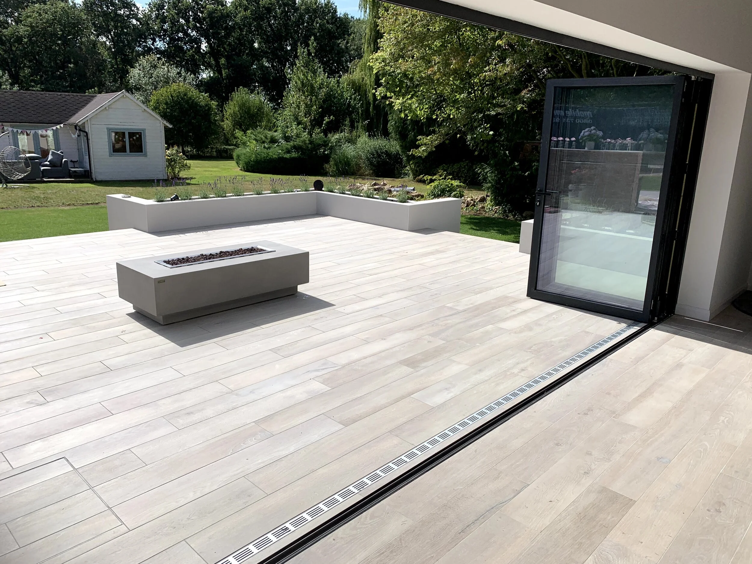An example of bringing the outdoors in, the use of a 1200x200 wood plank Porcelain tile flowing from the open plan lounge out to the patio area.
