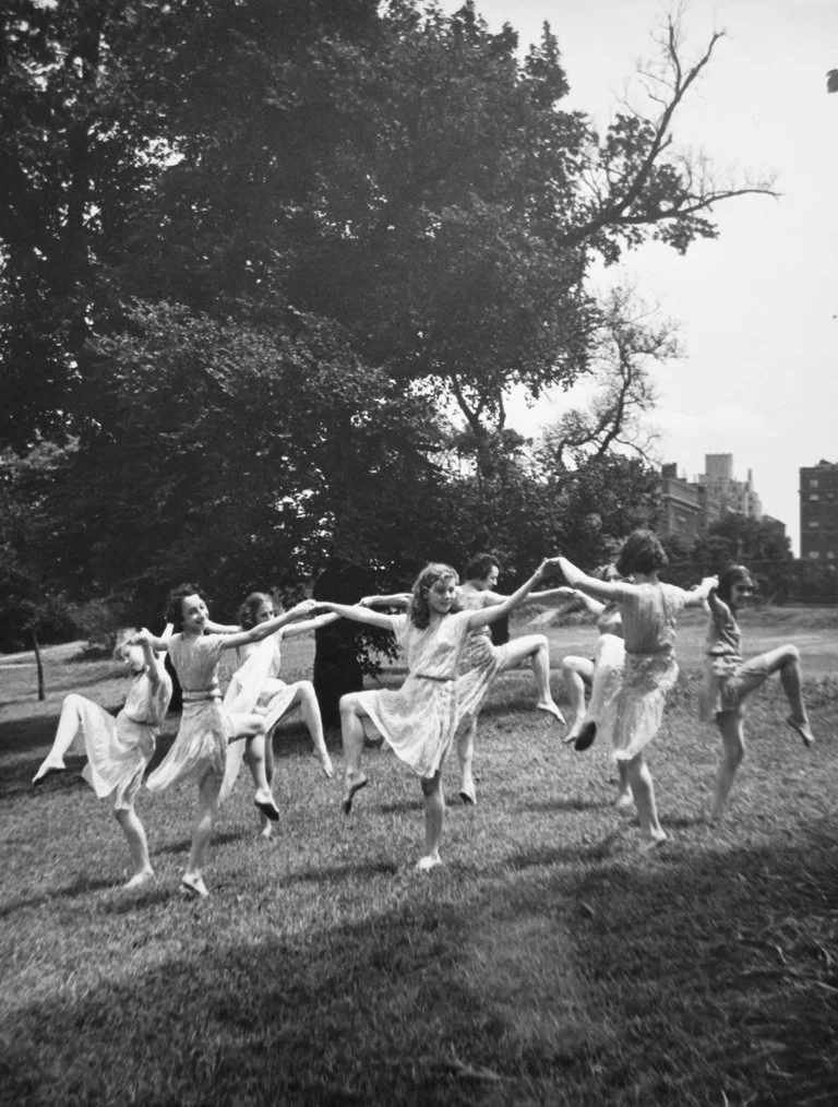 Group of young ladies holding hands forming a circle while dancing