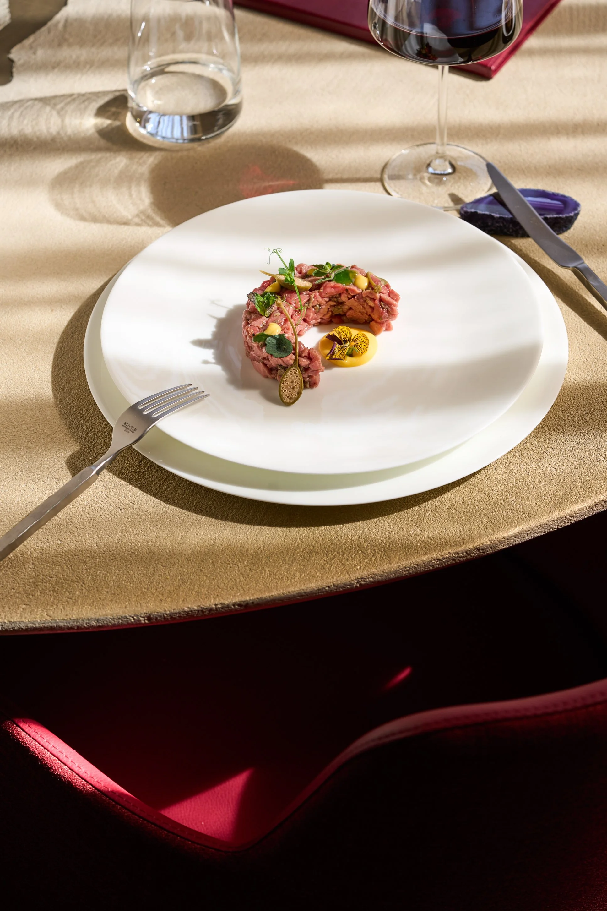 Fotografia food professionale di tartare di carne con fiori eduli e maionese, tavolo apparecchiato in ristorante fine dining a Milano — Cardinali Studio