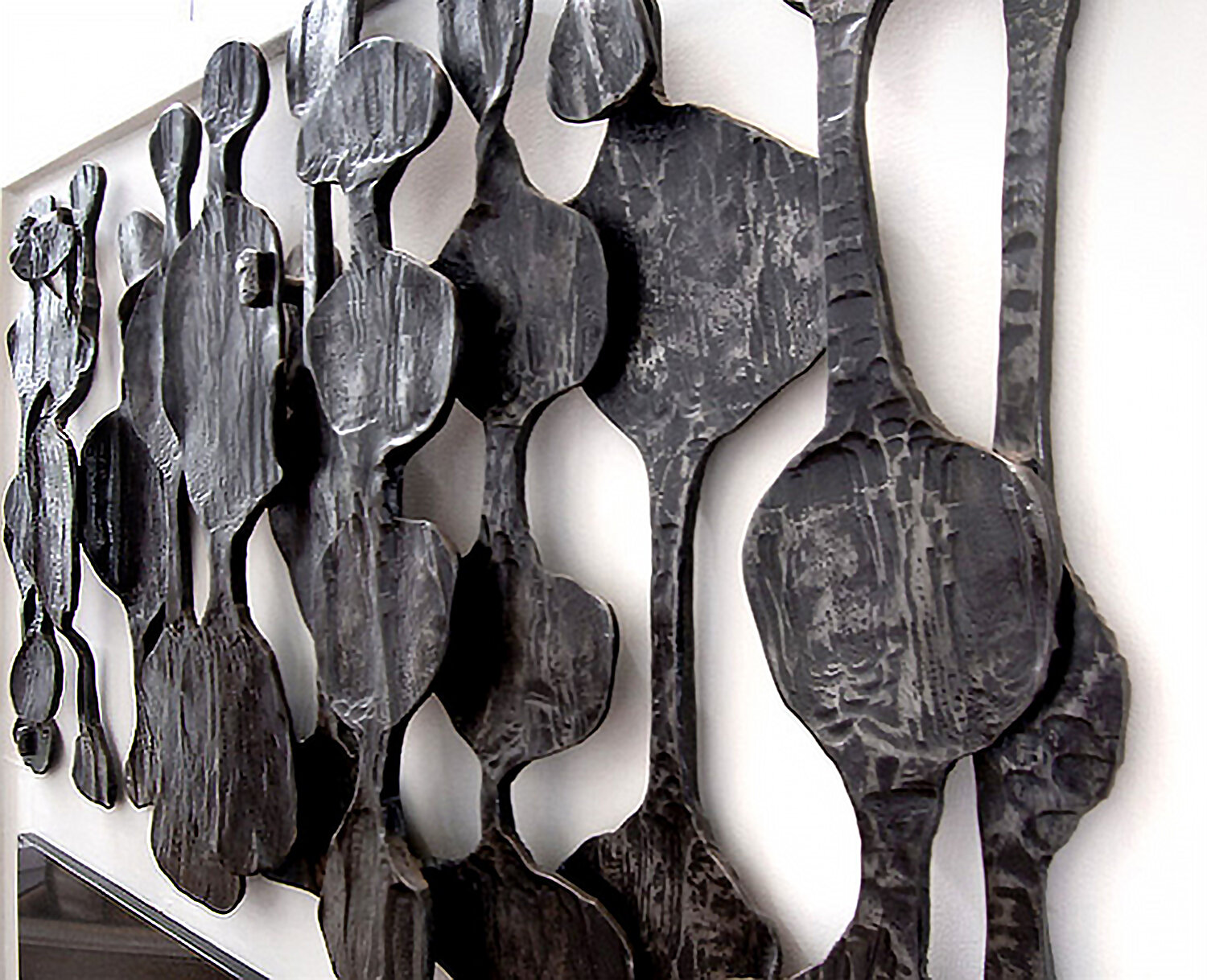  Detail of African Art-inspired wall relief sculpture. This residential artwork of forged steel was designed by Dimitri Gerakaris to resonate with the room full of antique African art. 