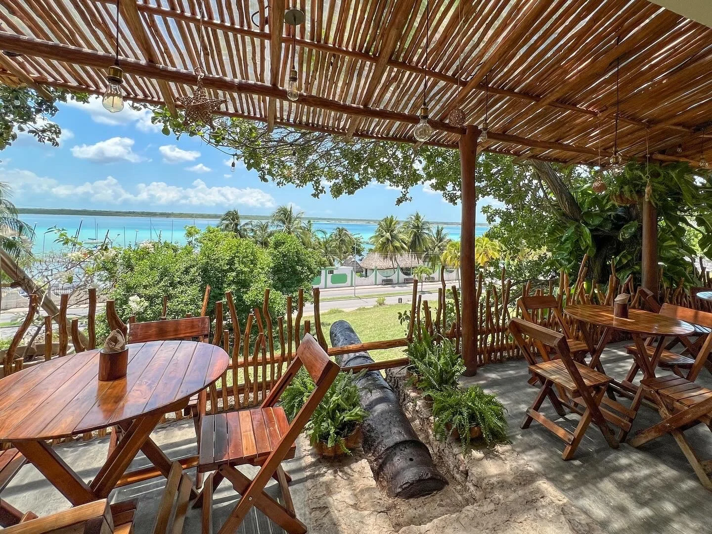 Outdoor restaurant terrace, hill view of the lagoon, right at the Fuerte San Felipe fort, with a historical cannon in the middle