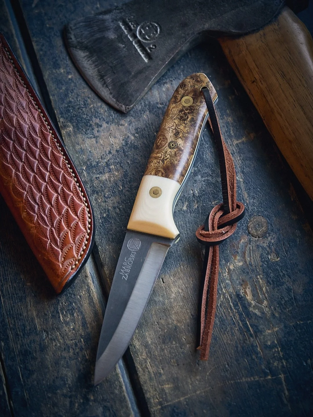 One from my own collection, the Taiga Bushcrafter. AEB-L stainless, shallow scandi, golden Amboyna Burl and Ivory Micarta.

The old maker&rsquo;s mark shows its vintage, and the years since have carried a fair bit of learning with them.