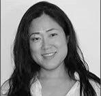 Black and white photo of a woman with long dark hair smiling.