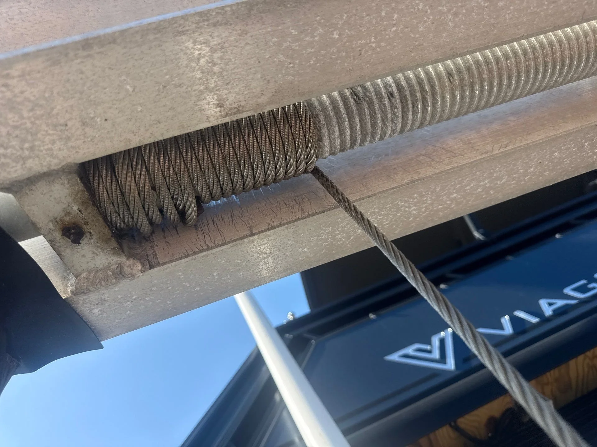Close-up inspection of boat lift cable and pulley system at dock