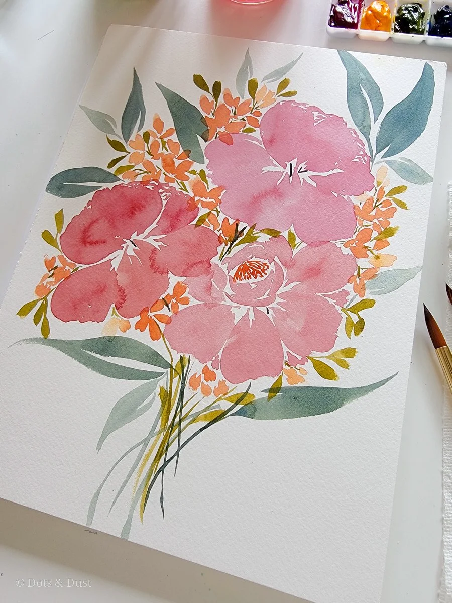 Watercolor painting of pink and peach flowers with green and gray leaves, on textured paper, with watercolor paints and a paintbrush nearby.