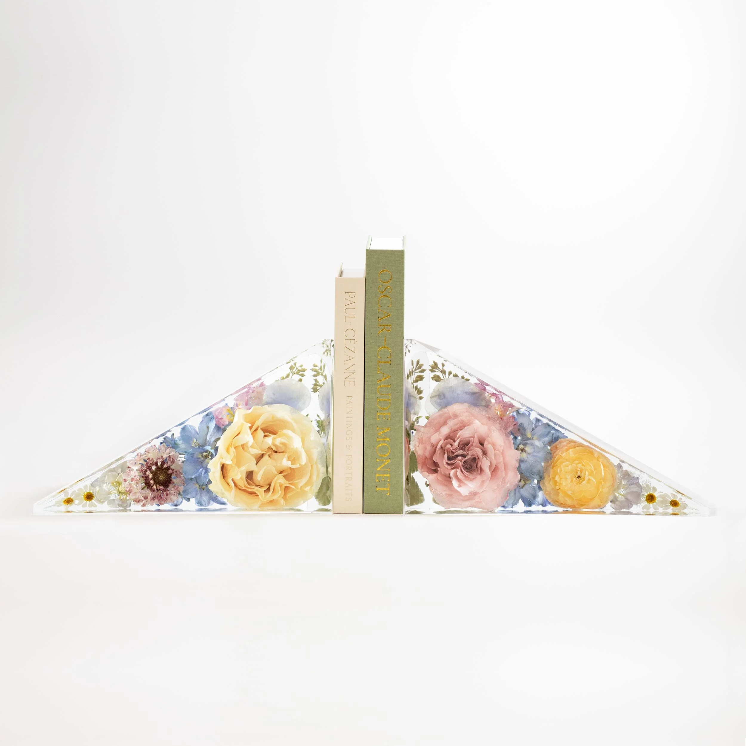 Pair of custom geometric triangle shaped resin flower bookends displaying preserved wedding bouquet blooms for a contemporary bookshelf mantel