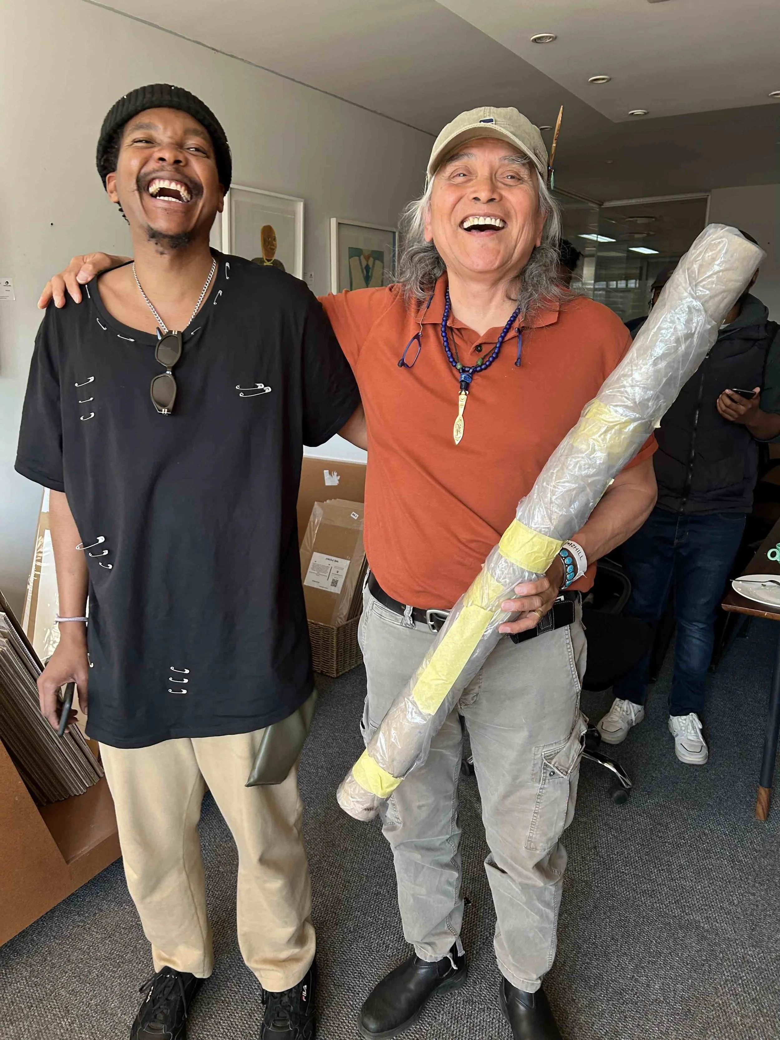 Xwalacktun accepting a gift from a student at Artist Proof Studio