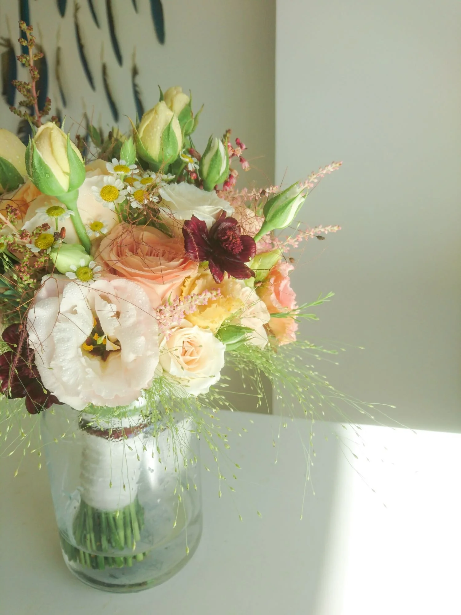 Summer bridal bouquet of mixed locally grown flowers. Bouquet da sposa estivo di fiori estivi di rose, lisianthus, camomila e altri fiori.