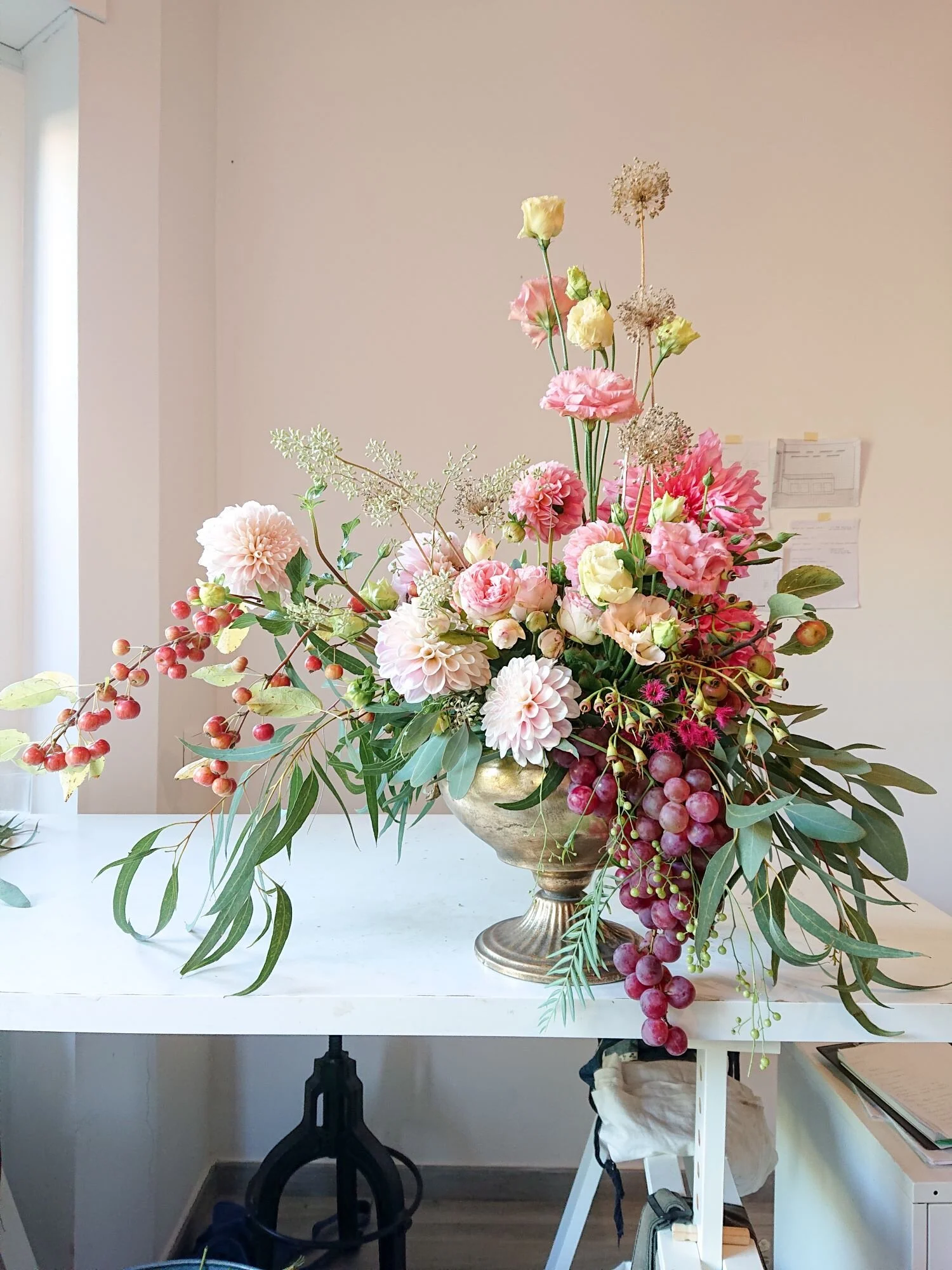 Urn arrangement of dahlias, lisianthus and grapes. Composizione di dalie, lisiantus e uva.