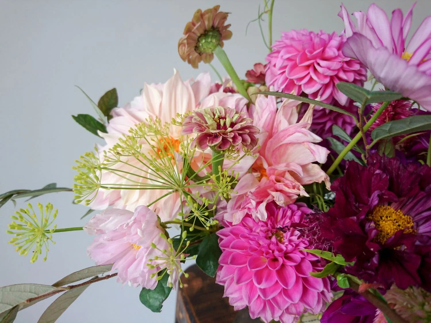 Details of an early autumn centerpiece. Pink dahlia, wind yellow fennel and other flowers. Dettagli di un centrotavola del inizio di autunno. Dalie rosa, finocchio giallo e altri fiori.