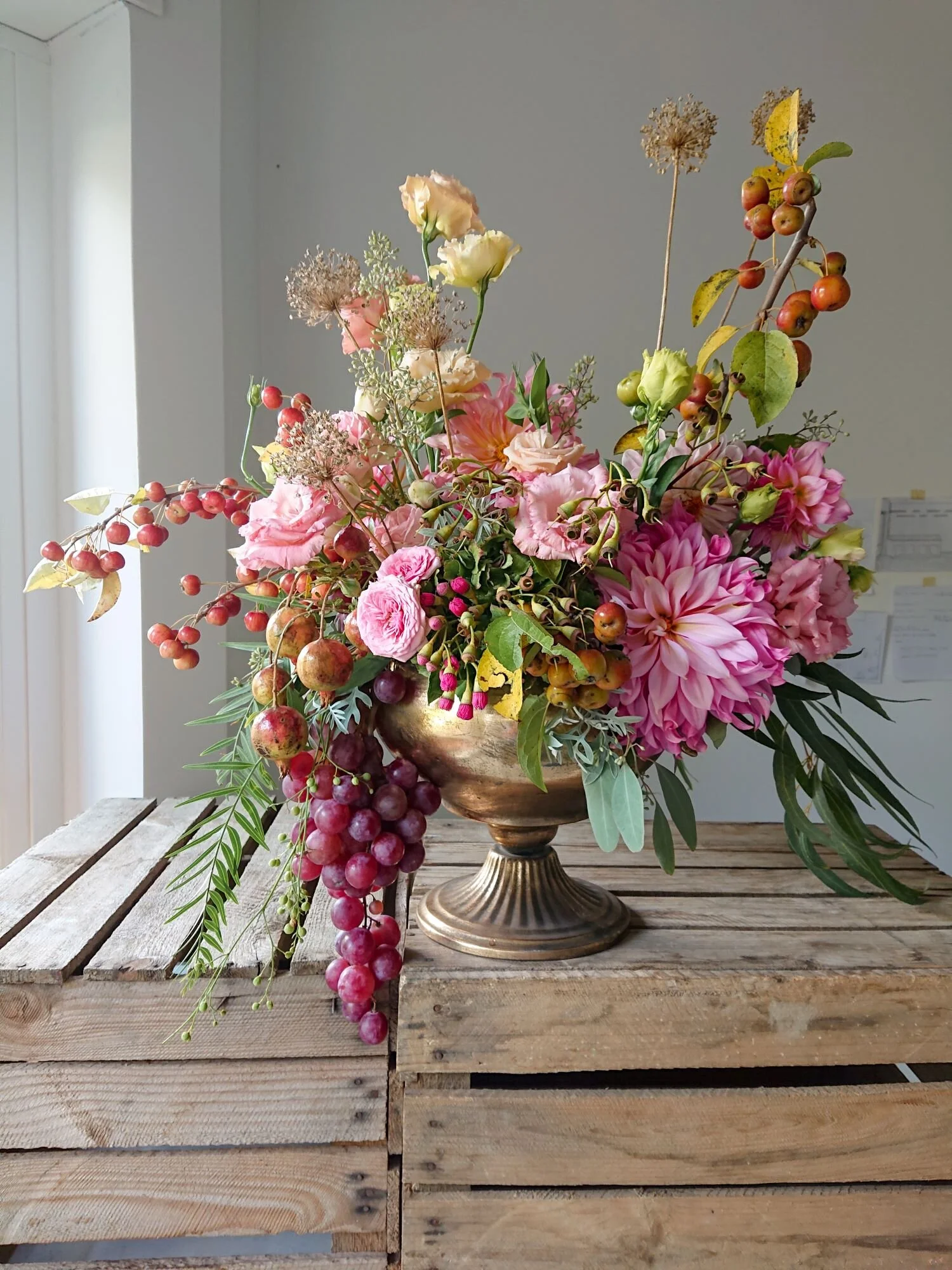 Urn arrangement of dahlias, lisianthus and grapes. Composizione di dalie, lisiantus e uva.