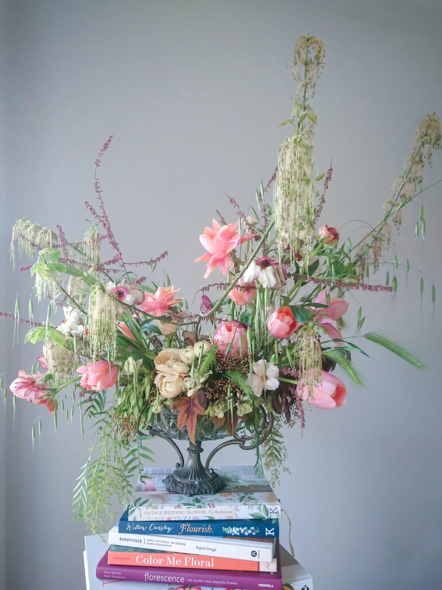 Early spring urn arrangement of tulips, ranunculus and unusual foraged greenery