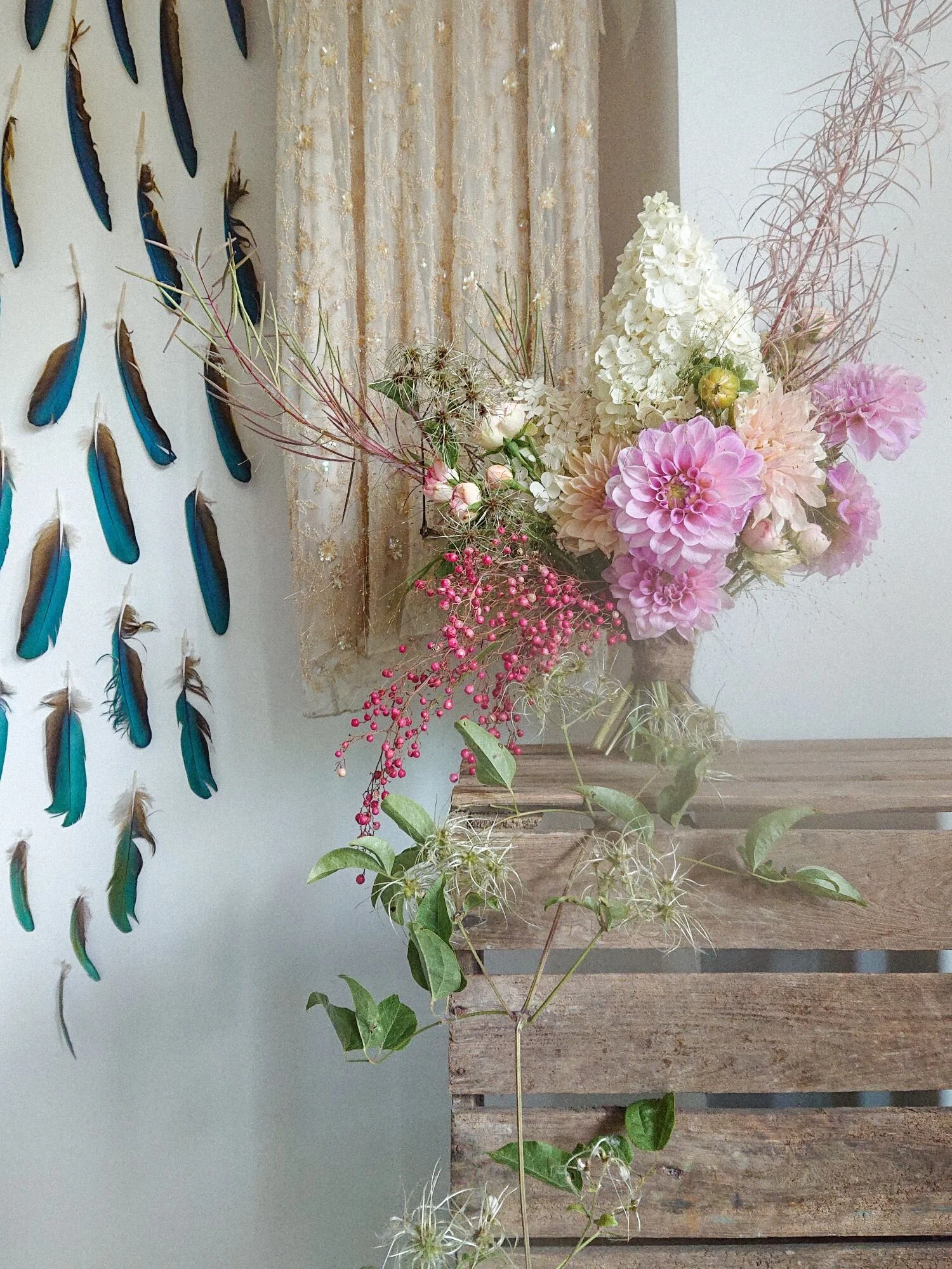 Pink august flowers on a wooden crate. Summer bridal bouquet of dahlias, spray roses, foraged textures.  Fiori di estate rosa. Bouquet da sposa in agosto.