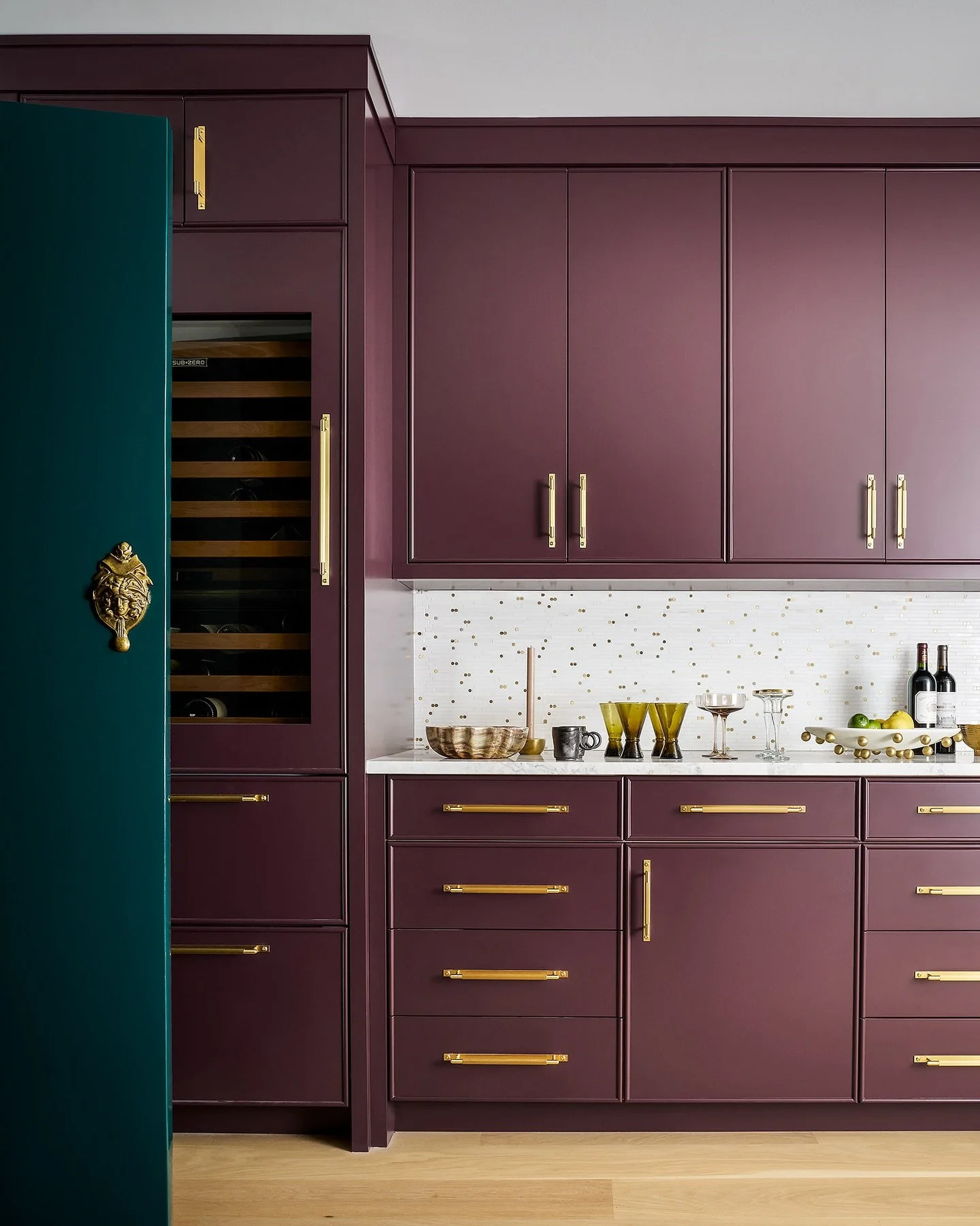 This bar was such a dream to re-design. In the renovation, we introduced custom cabinetry in a high-gloss aubergine lacquer. To complement, we installed a mosaic backsplash featuring marble and brass, which brought beautiful texture and warmth behind