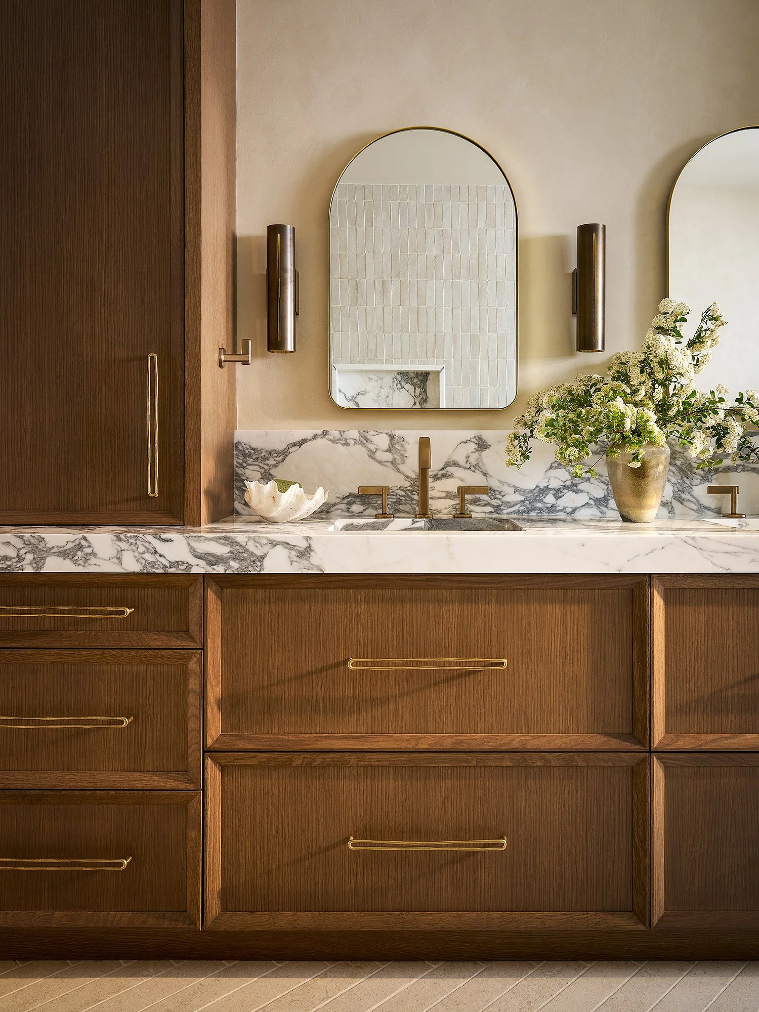 Luxury bathroom with custom wood vanity, double sinks, marble countertop, and tadelakt plaster walls, front view.