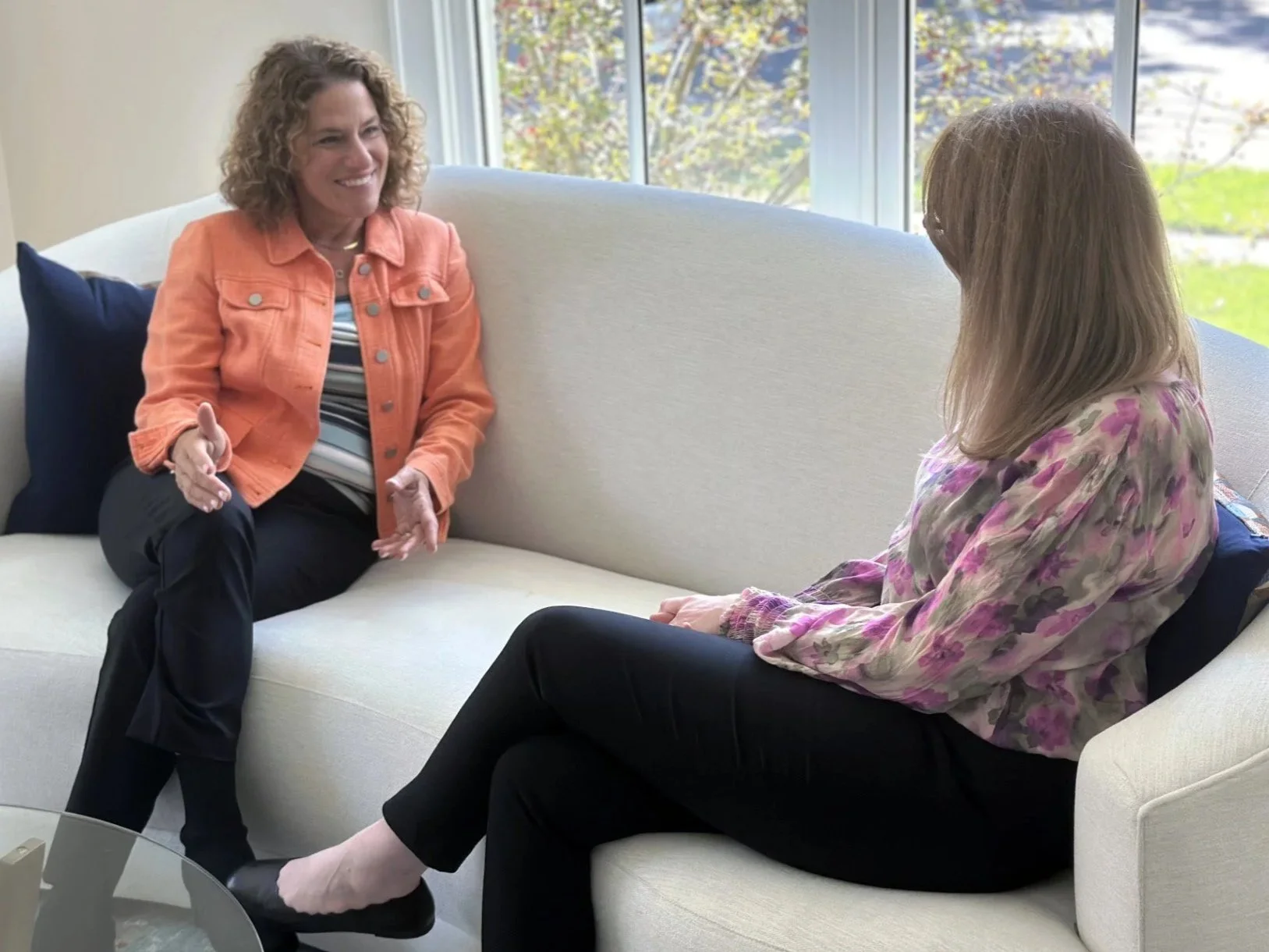 Tammy Jersey sitting on a white couch having a conversation about Executive Search.