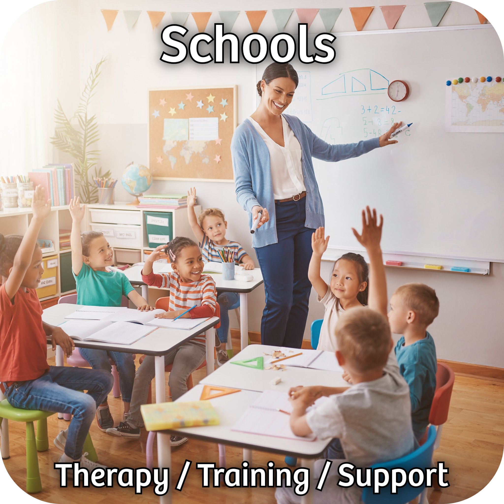 Primary school teacher standing in a classroom asking pupils questions who are sat at tables with a hand up.