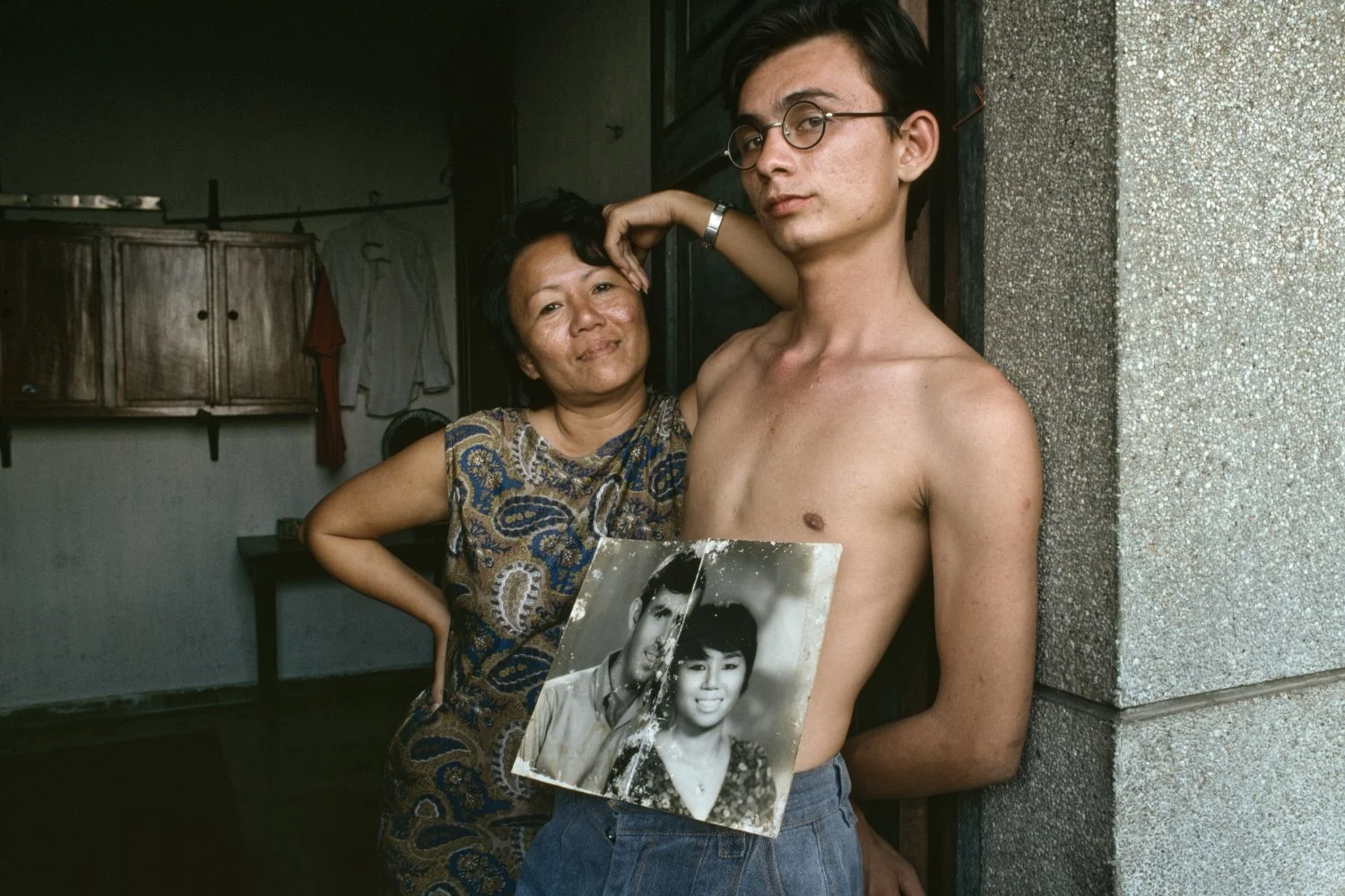 JIM AND HIS VEITNAMESE MOTHER SHOW A PHOTOGRAPH OF HER WITH HER AMERICAN HUSBAND. THEY WERE A FAMILY UNTIL THE FATHER DECIDED TO RETURN HOME TO A FAMILY HE ALREADY HAD, AND HAD KEPT SECRET. - 1990