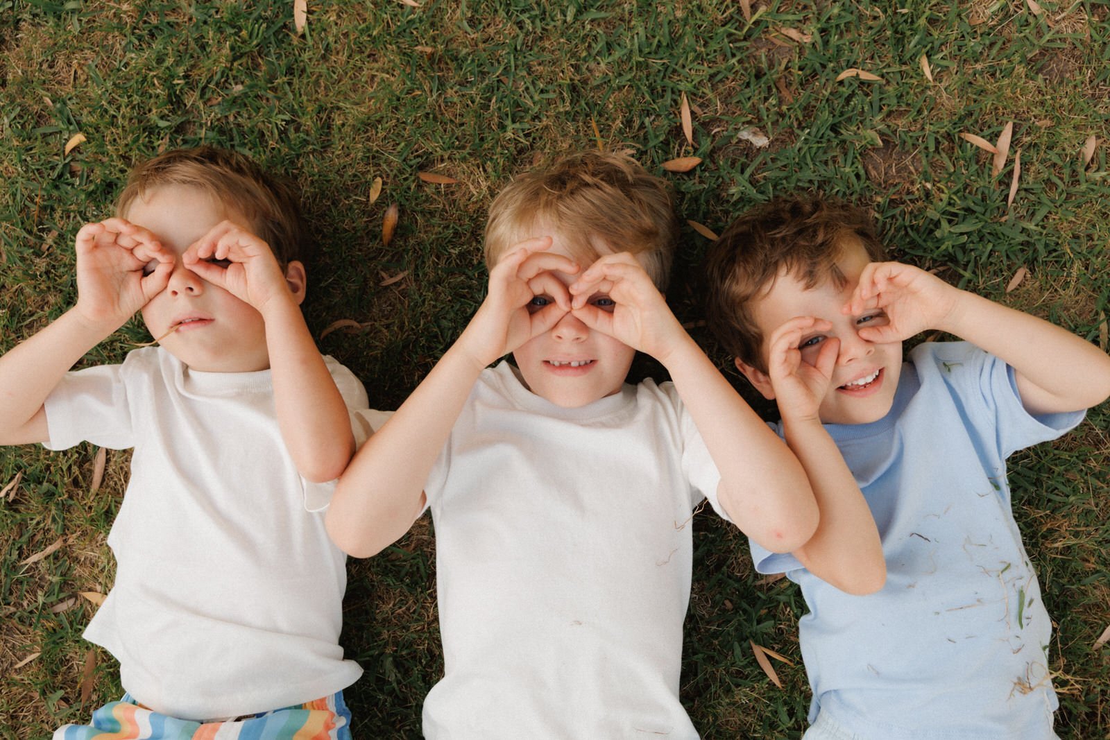 three boys laying on the grass natural family photos.JPG