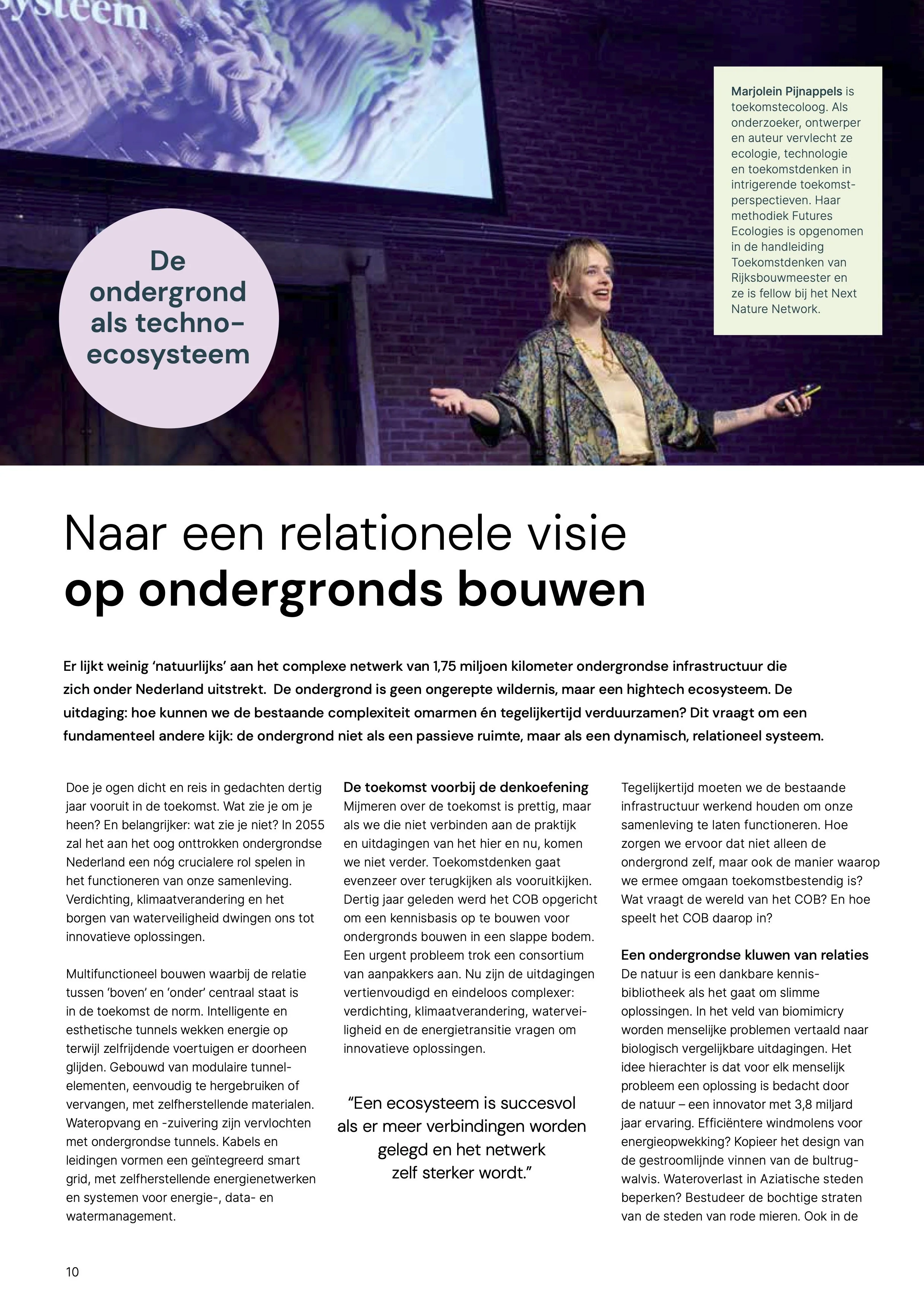 Een vrouw die spreekt tijdens een conferentie met een grote scherm aan de muur achter haar en een tekstballon met de tekst 'De ondergrond als techno-ecosysteem'.