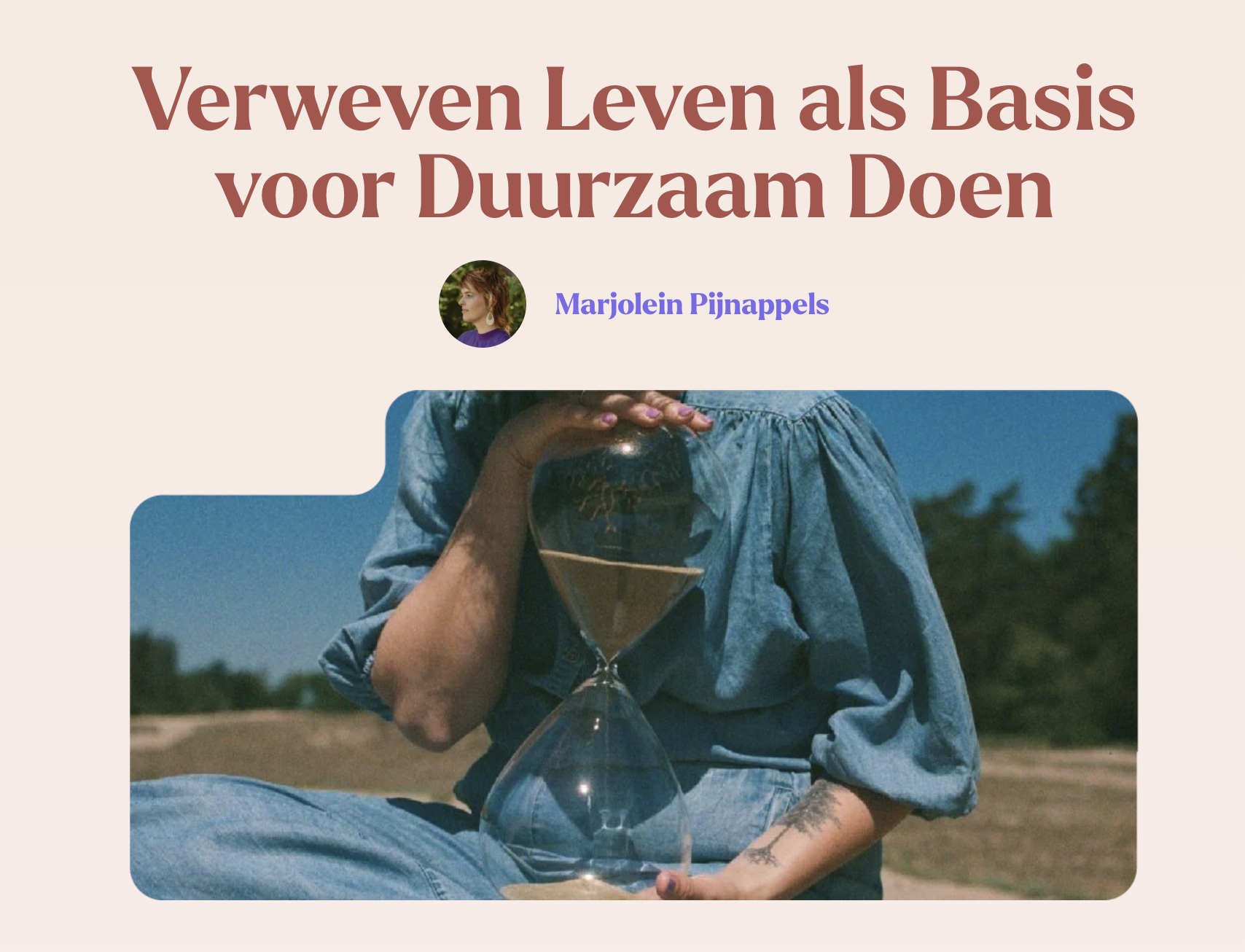 Een persoon met een denim shirt die een glazen bol vasthoudt, zittend buiten op een landelijk gebied op een zonnige dag.