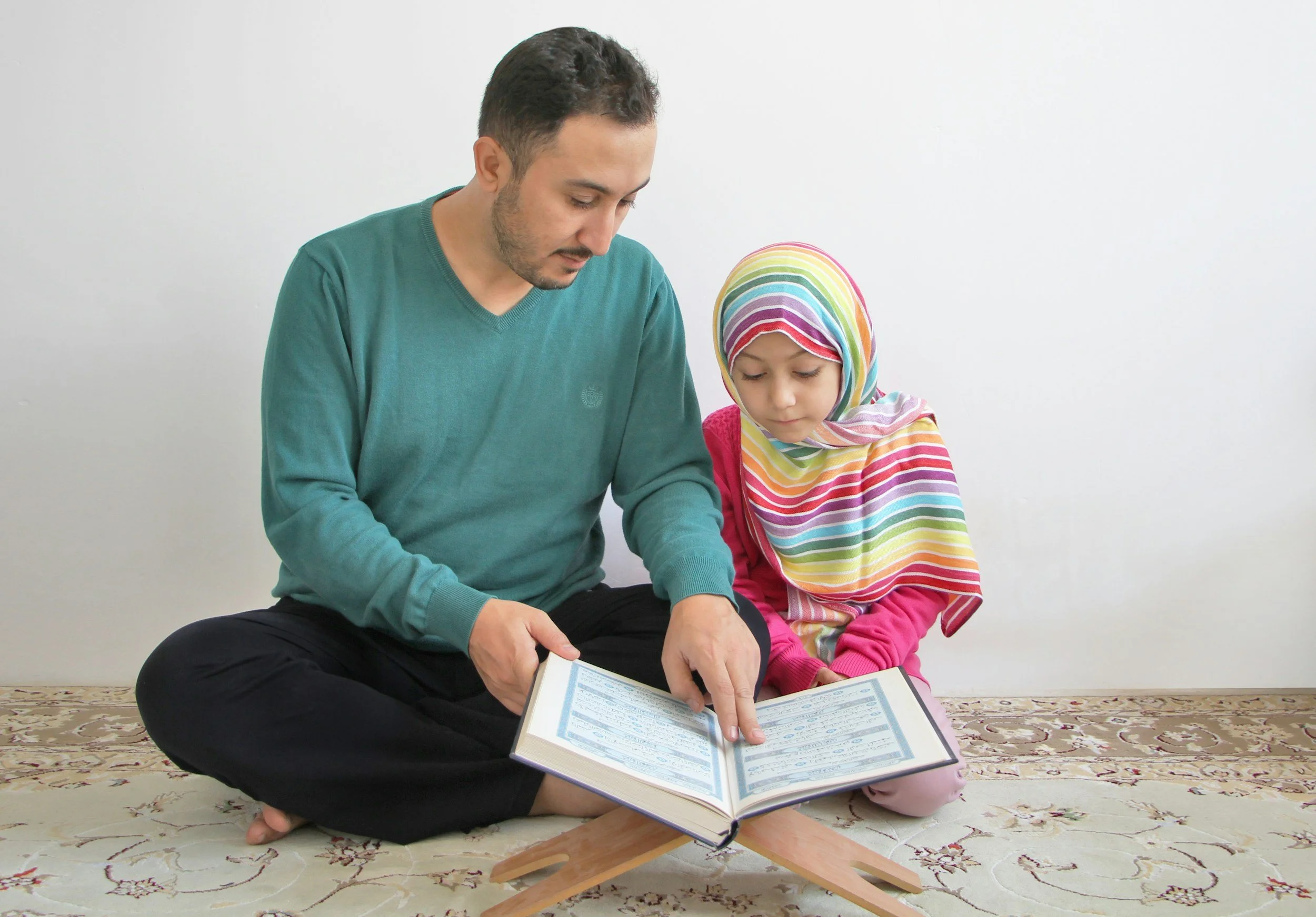 father and daughter reading Quran