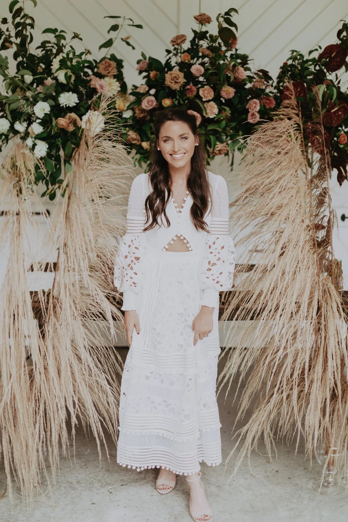 Owner posing in front of flower designs