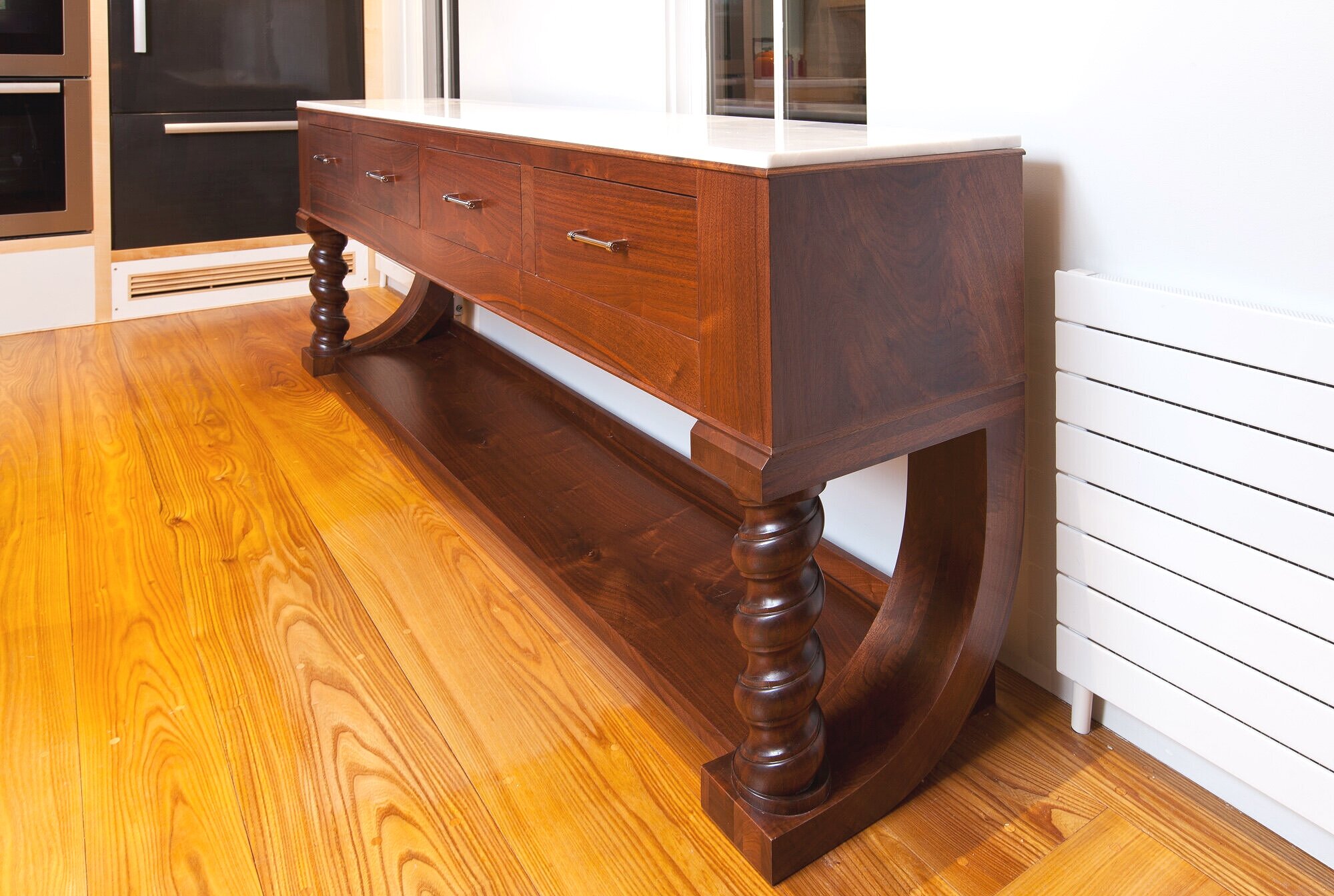 Walnut credenza , freestanding furniture designed for this kitchen creates a focal point separate from the sameness of the cabinetwork. 'Mystery white'
marble top.