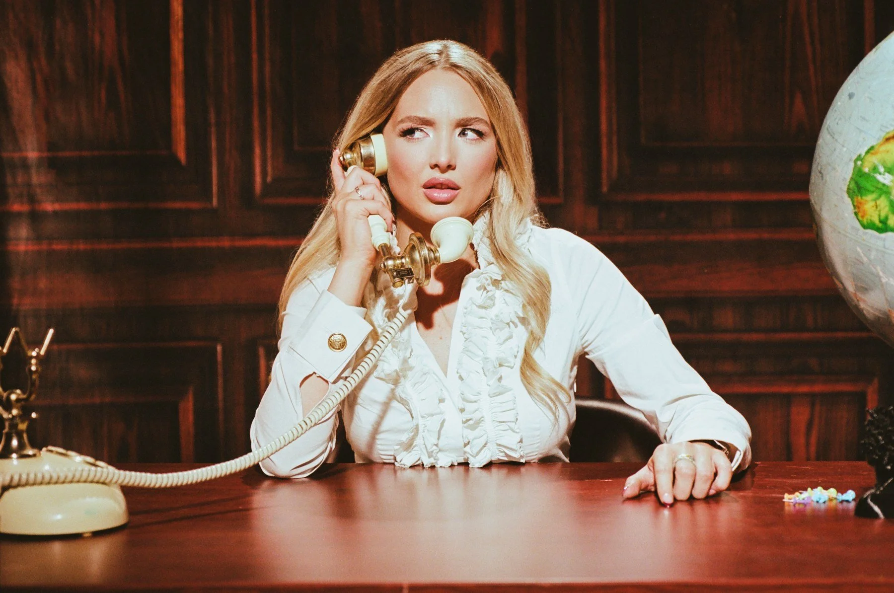 Editorial portrait at wood panel office set with vintage phone, Lightbox OKC studio rental