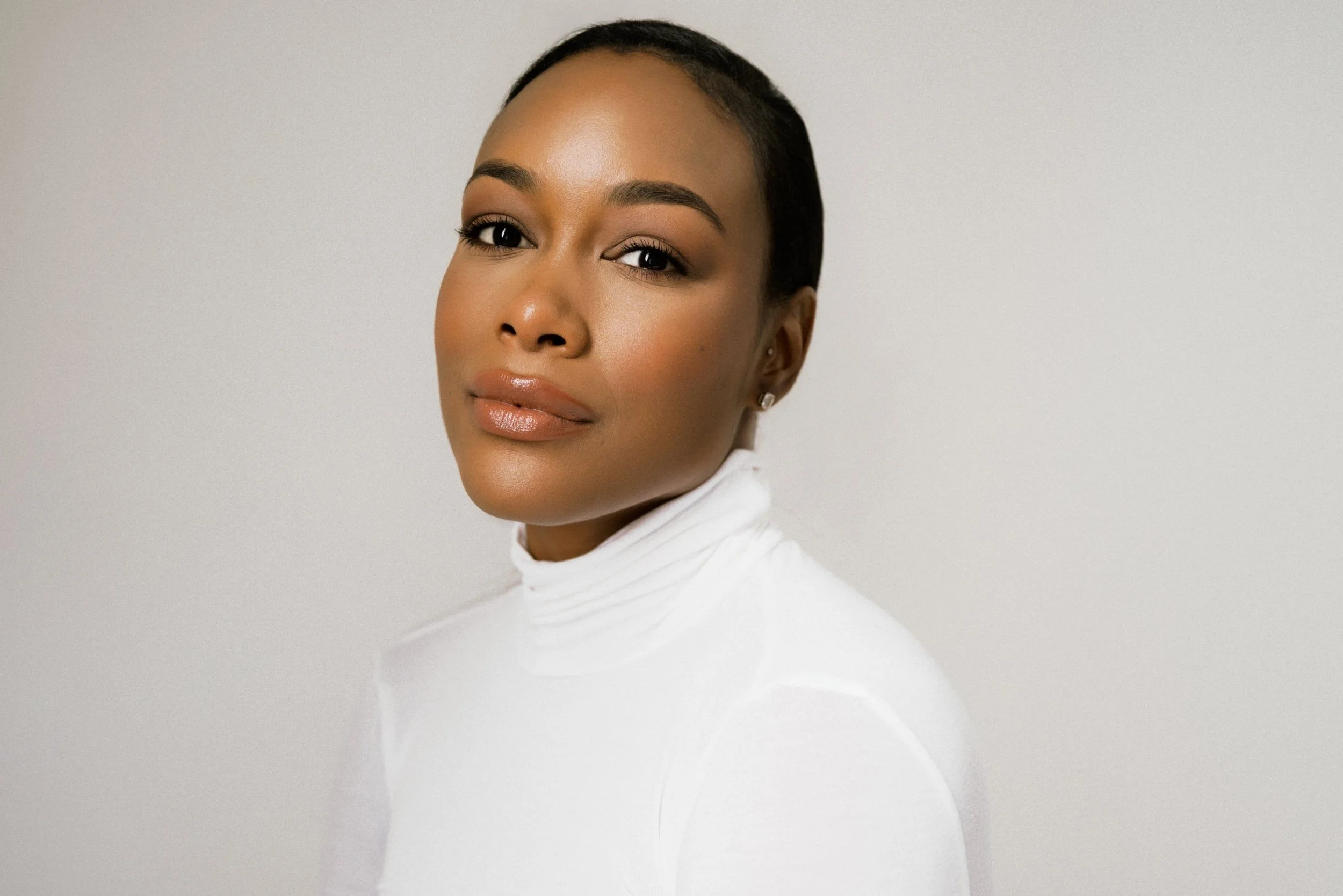 Professional headshot in white turtleneck on gray seamless at Lightbox OKC, Oklahoma City headshot studio