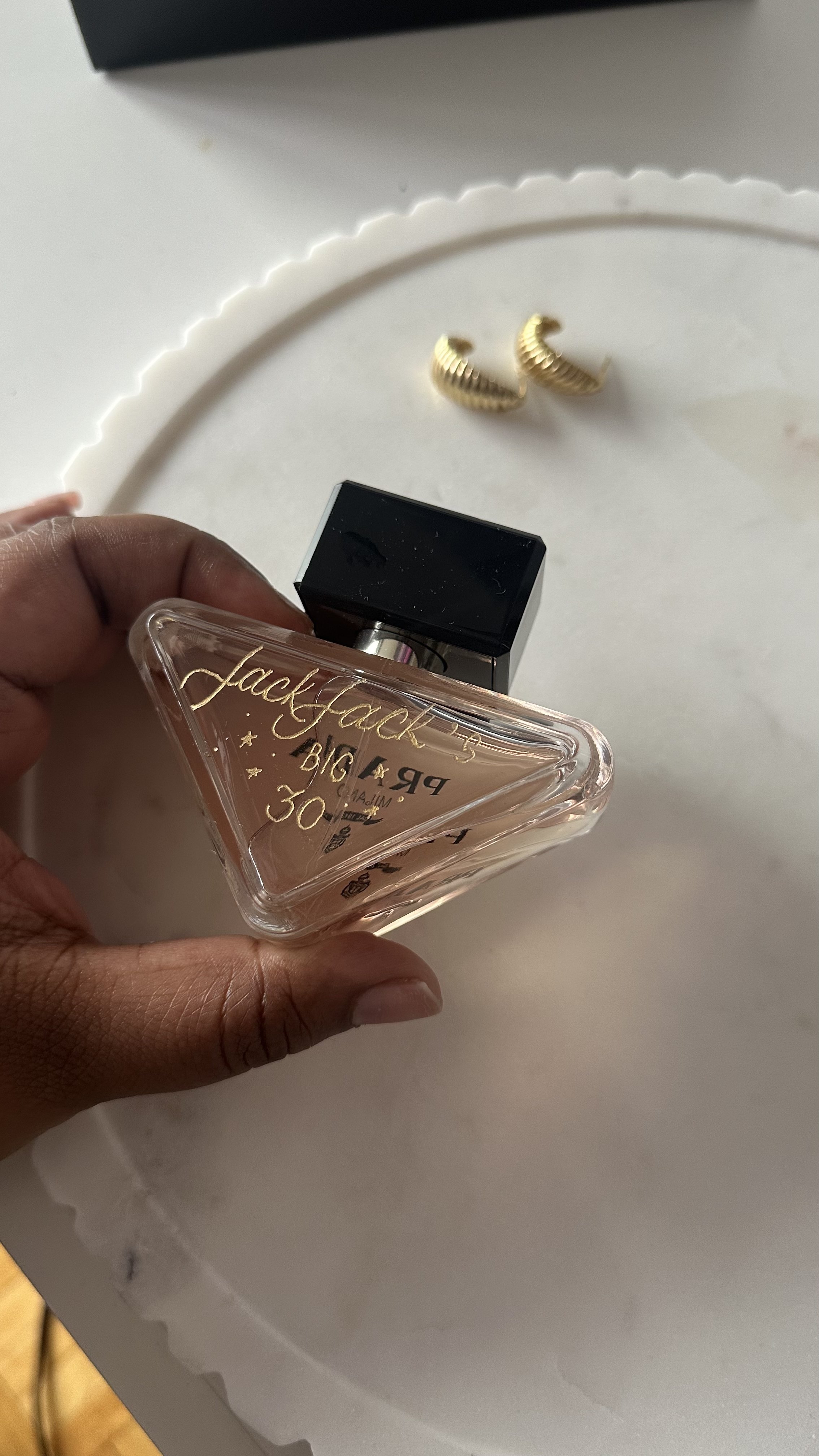 Hand engraving on a Prada perfume bottle, showcasing personalized lettering for a luxury gift or event - Didi Letters
