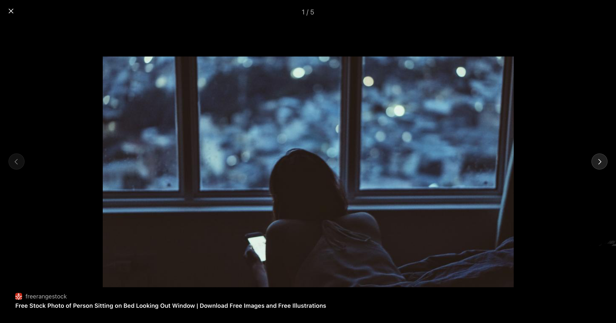 A person sitting quietly by a window at night, illuminated by soft light, reflecting on inner life and emotional support.