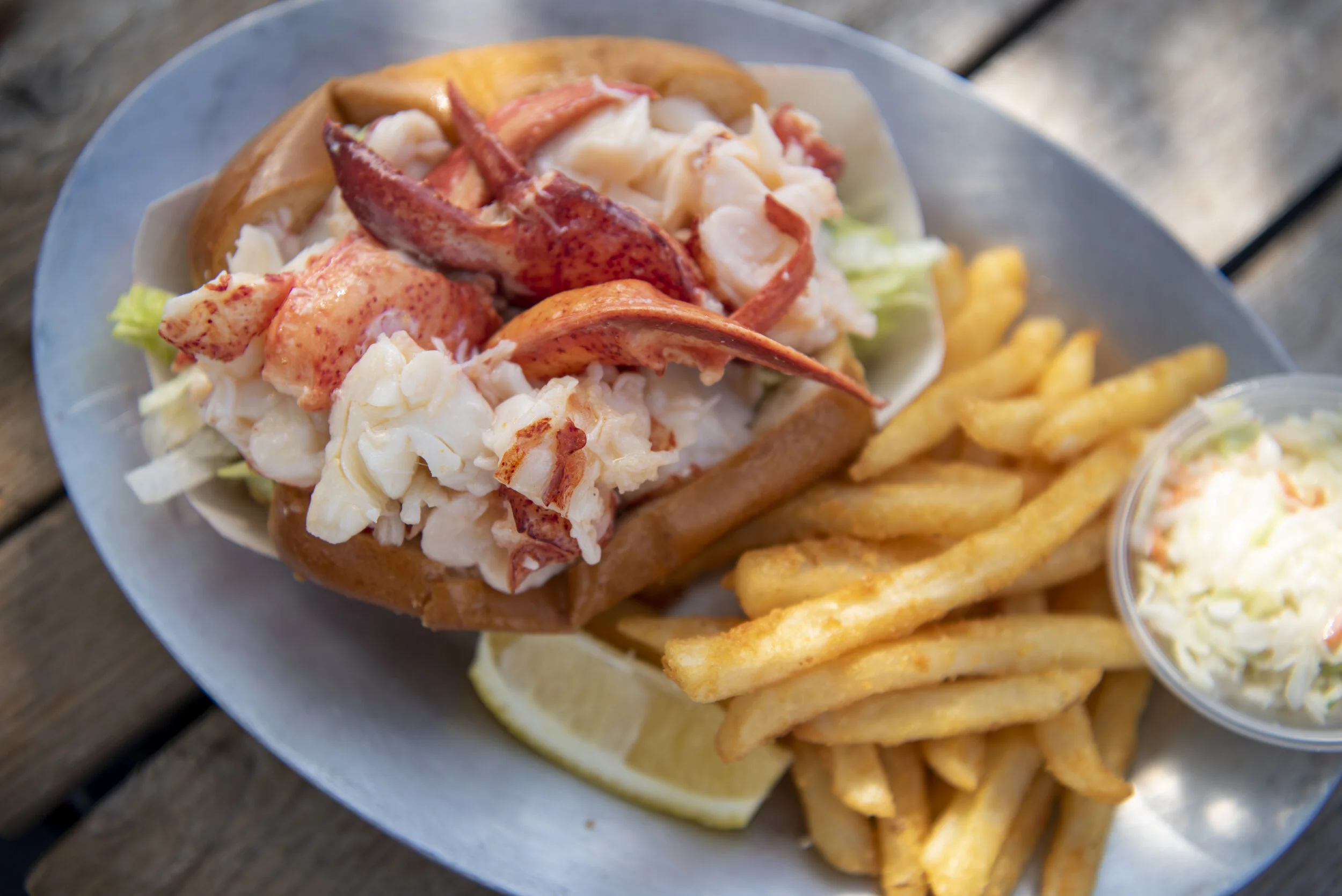 Plated lobster roll with clear claw meat showing the quality of the ingredients.