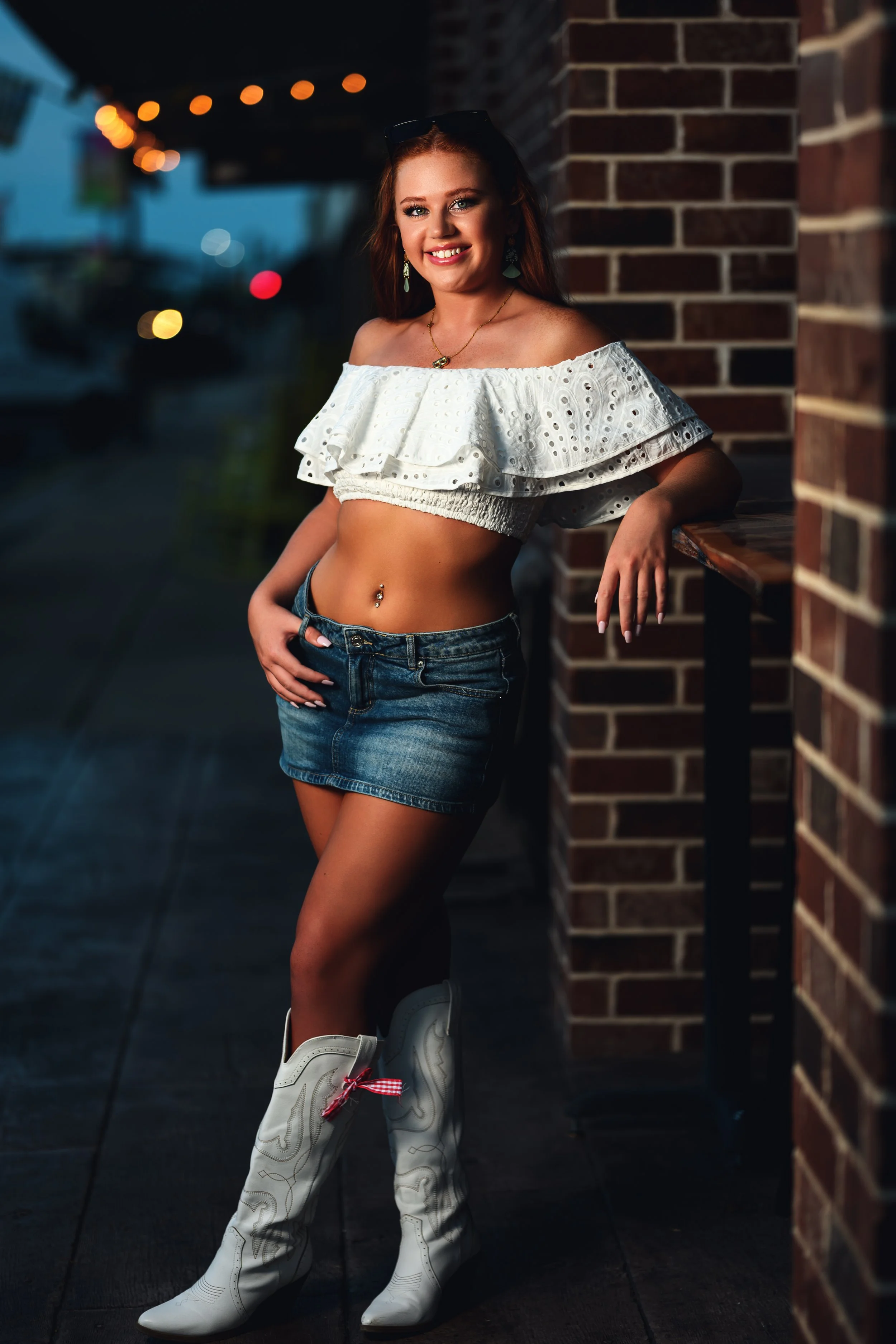 Young woman downtown Lebanon, MO summer outfit with lights in the background.