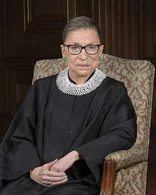 Photo of Ruth Bader Ginsberg, in judicial robe, sitting in a chair