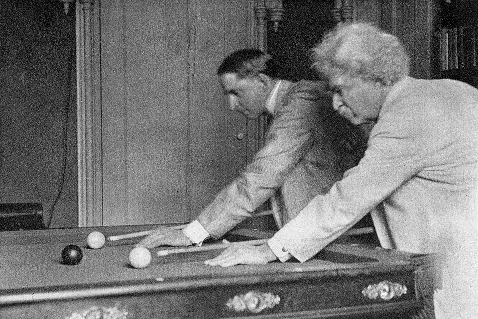 Grainy B&W photo of two men playing billiards