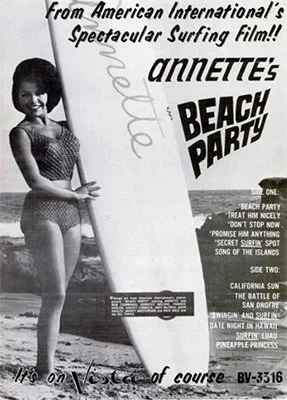 Ad with a B&W photo of Annette Funicello in a bathing suit, holding a surfboard