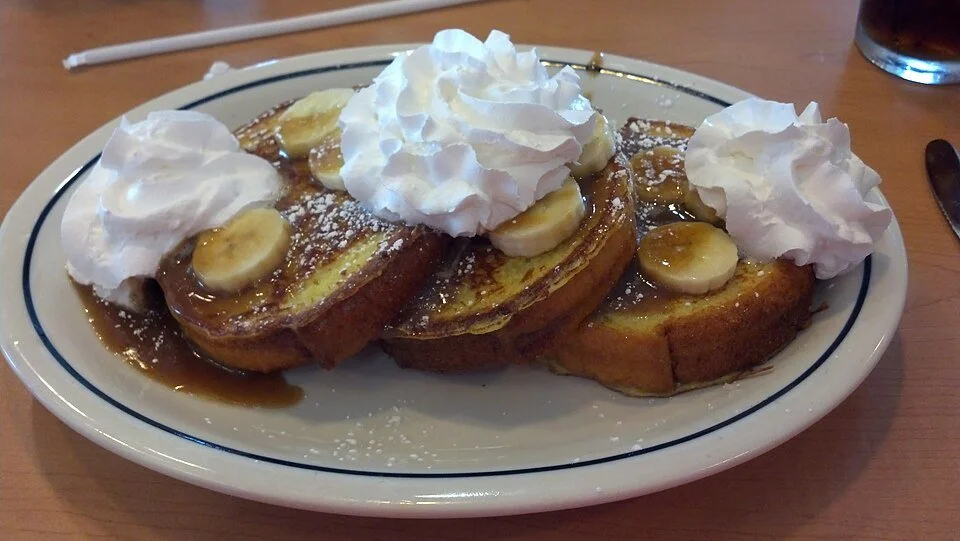 Photo of a dish of bananas Foster served over brioche French toast