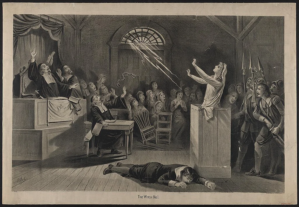 A 17th-century court in an uproar, a woman in the dock, lightning comes through a window, a man lies prone on the floor