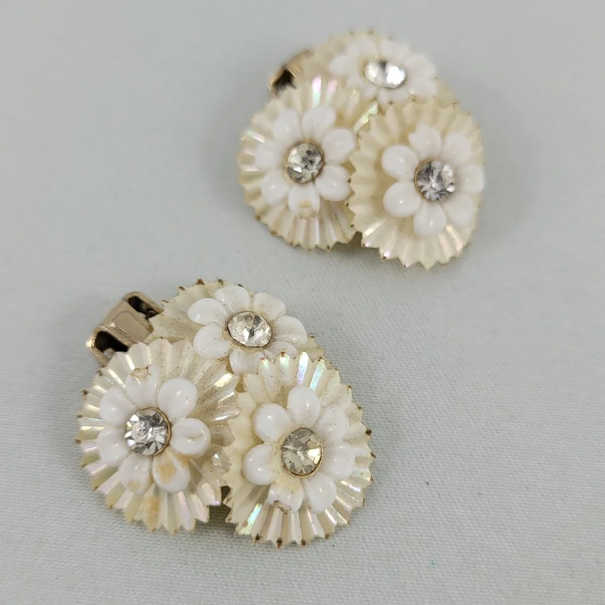 1950's Domed Triple Flower Riveted Rhinestone Iridized Shiny Soft White Plastic 1 Inch Clip Earrings -1.jpg