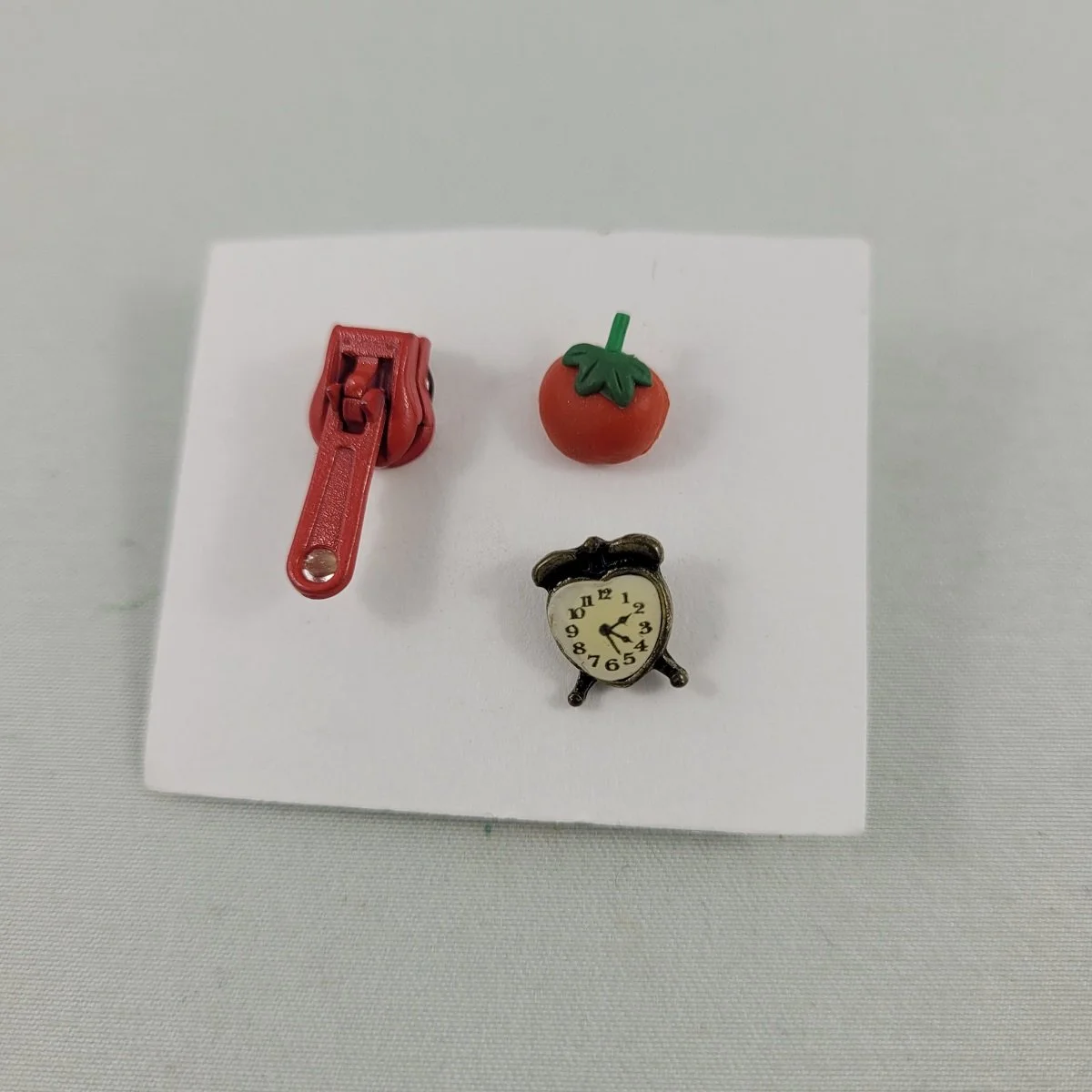 SET of Three Waggish Pierced Earrings Rubberized Tomato Resin Heart Alarm Clock Articulated Rhinestone Enameled Zipper Front View