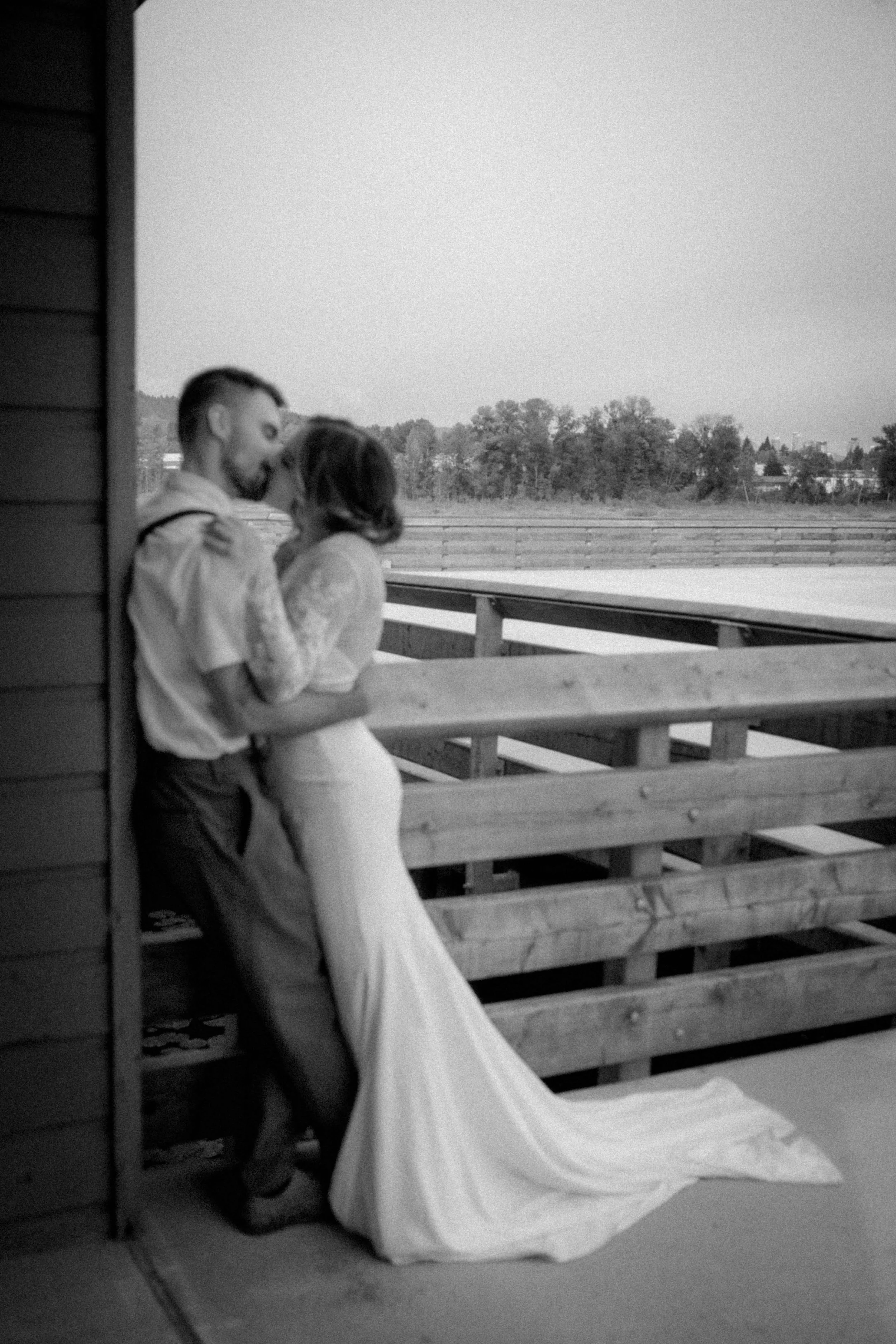 A black and white image of a bride and groom kissing at the Burnaby Lake Pavilion