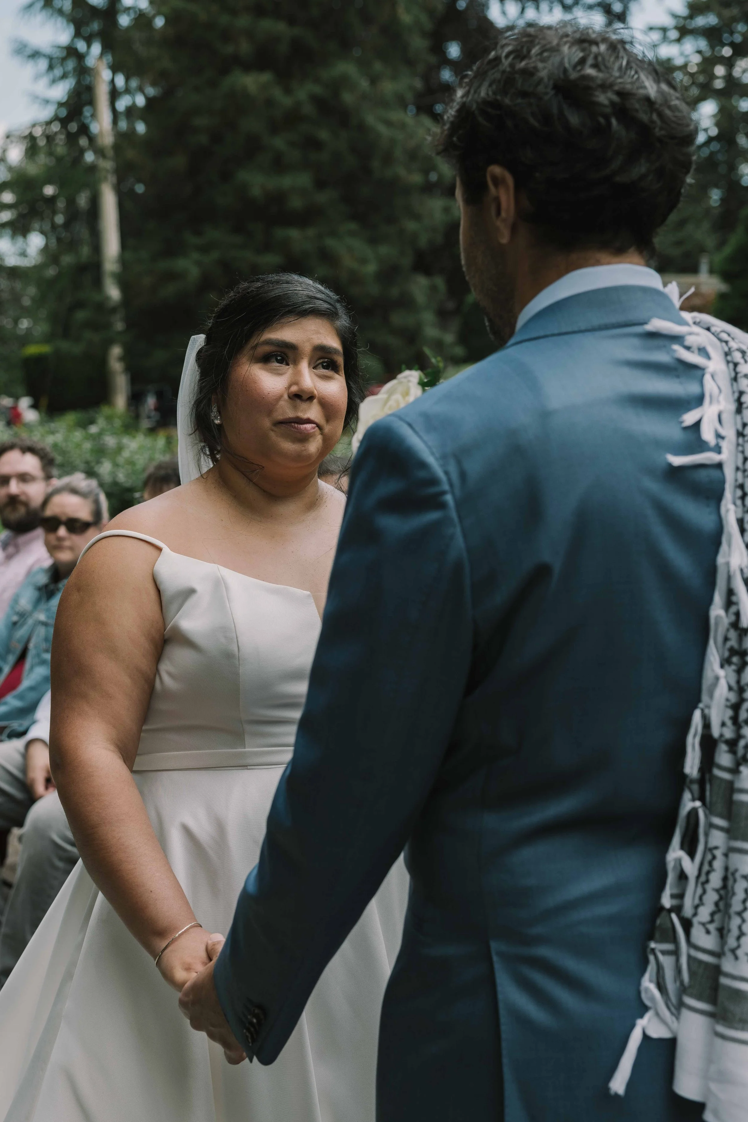 A Latino Bride with a side bun gazes and her groom on her wedding day.