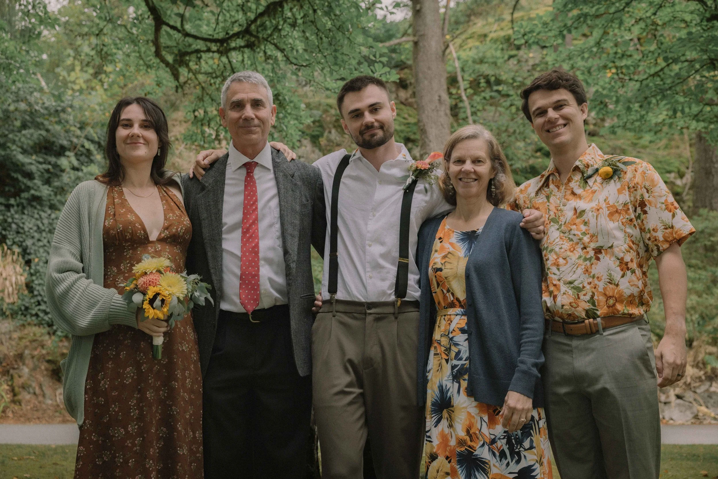 The groom with an embroidered collar stands with his family at Minnekhada Lodge