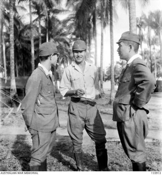  Captain Susumi (centre) in discussion with his legal team at the War Crimes Trial.   Courtesy AWM.  