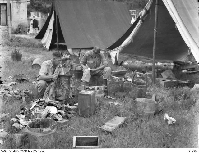  Investigators sifting through personal items of prisoners.   Courtesy AWM 