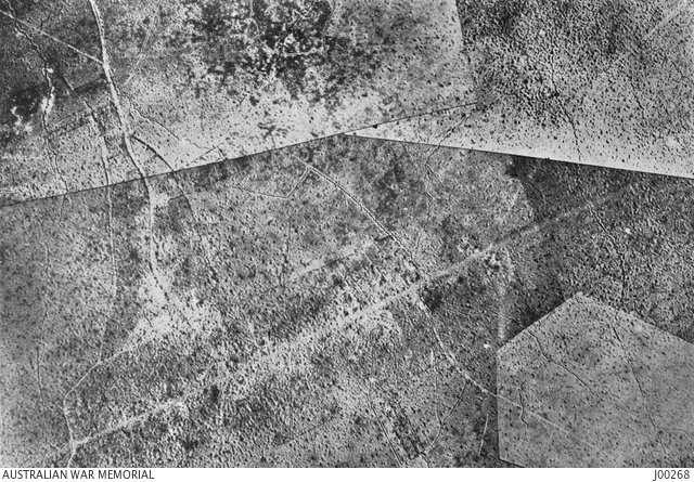  Aerial photograph of the battlefield. The road running along the south is the Bapaume Road. The remains of the village run along the centre of Bapaume Road.   Courtesy AWM.   