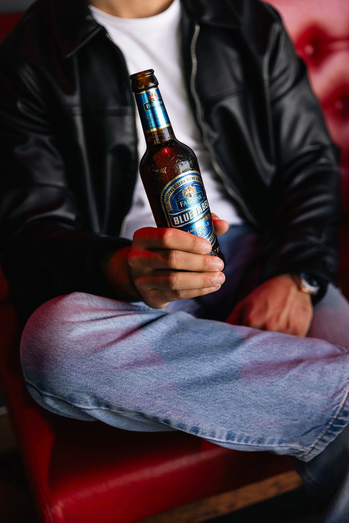 guy holding a blue label classic brews bottle, indoors